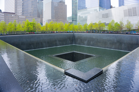 NEW YORK CITY, USA - MAY 01, 2016: New York City, Memorial at Ground Zero, Manhattan, commemorating the terrorist attack of September 11, 2001. Flowers near the names of victims engraved in the bronze parapet.のeditorial素材