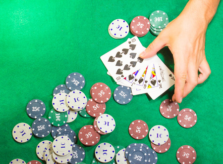 The male hands with cards in casino and chips