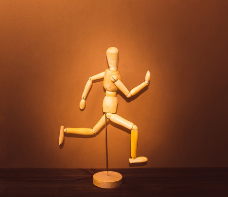 The figure of wooden man, running on wooden backgroundの写真素材