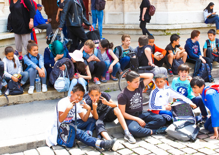 Lyon, France - June 16, 2016: group of children sitting on the steps of the cathedral in the old town at Lyon, Franceのeditorial素材
