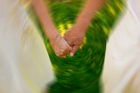 Concept shoot of friendship and love of old man and woman: two hands over green grassの写真素材