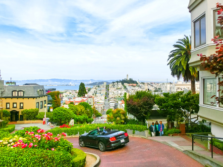 San Francisco, California, United States of America - May 04, 2016: View of Lombard Street in San Francisco, California, USA. Lombard street is crookedest street in the world. People are driving the car and making a photo, other people are walking along tのeditorial素材