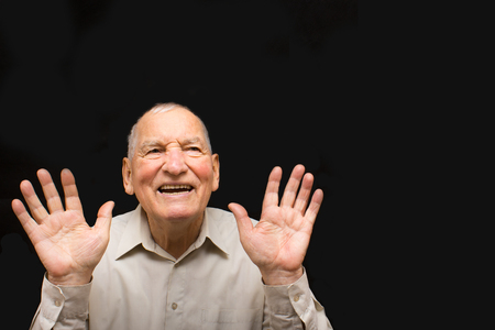 The happy elderly man on the black backgroundの写真素材