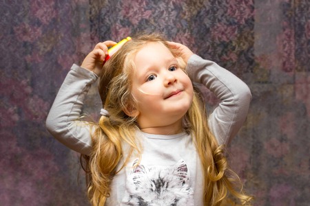 Little girl with a toy as mobile phone at homeの写真素材
