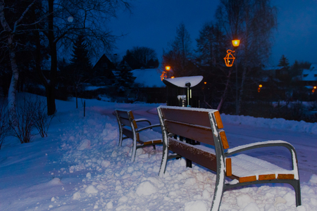 Bench in the park covered with snowの写真素材