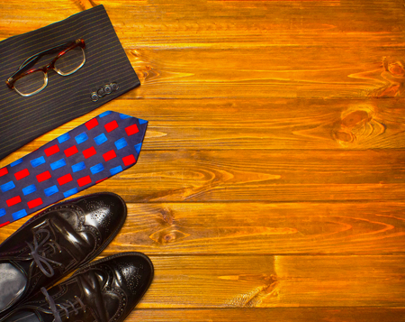 The elegant male set: mens shoes, suit, tie on wooden background.の写真素材