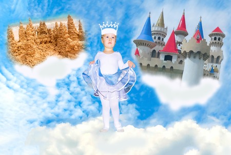 Little girl in a princess dress in front of a pictured castlesの写真素材
