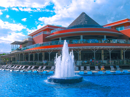 Punta Cana, Dominican republic - February 04, 2013: Ordinary tourists resting in Barcelo Bavaro Beach hotel with pool under palmsのeditorial素材