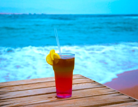 The cocktail with blur beach on background