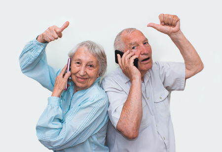 Senior couple at home using smartphonesの写真素材