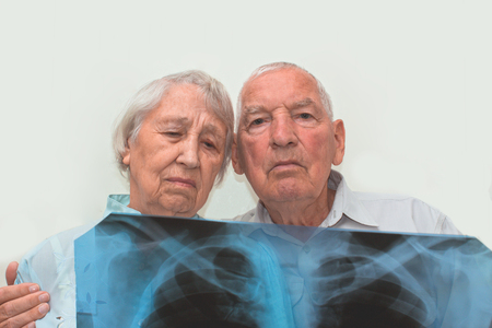 The medicine, age, health care and people concept - the sad senior woman and man looking at...