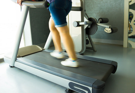 Fitness girl running on treadmill. Woman in gym