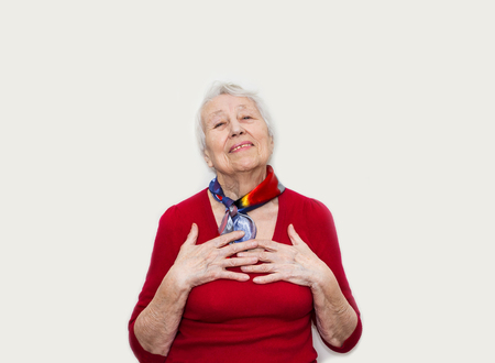 Happy smiling retired senior woman looking at camera isolated on white backgroundの写真素材