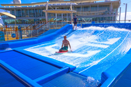 Falmouth, Jamaica - May 02, 2018: Woman surfing on the FlowRider aboard the Oasis of the Seas by Royal Caribbeanのeditorial素材
