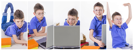 Portrait of cute schoolboy sitting with books and typing on laptop keyboard