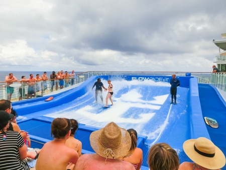 Cape Canaveral, USA - APRIL 30, 2018: Woman surfing on the FlowRider aboard the Oasis of the Seas by Royal Caribbeanのeditorial素材