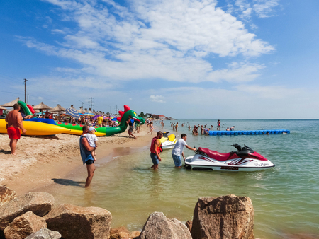 Berdyansk, Ukraine June 30, 2018: beach resort seasonon the coast of the Azov Sea. People are sunbathing on the beach.のeditorial素材