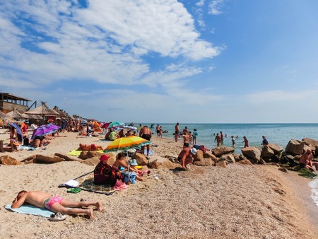 Berdyansk, Ukraine June 30, 2018: beach resort seasonon the coast of the Azov Sea. People are sunbathing on the beach.のeditorial素材