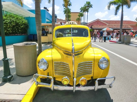 Orlando, Florida, USA - May 10, 2018: The people going near yellow retro car taxi at Universal Studios Orlando. Universal Studios Orlando is a theme park resort in Orlando, Florida.のeditorial素材