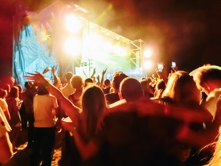 The party, concert concept. Crowd raising their hands and enjoying great rock festival. blur bokeh for background.の写真素材