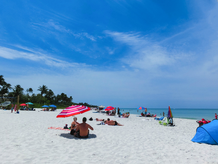 Naples, USA - May 8, 2018: Tourists enjoying the Vanderbilt beach in Naples, Florida. Naples is located on the Gulf Coast in southern Florida.のeditorial素材