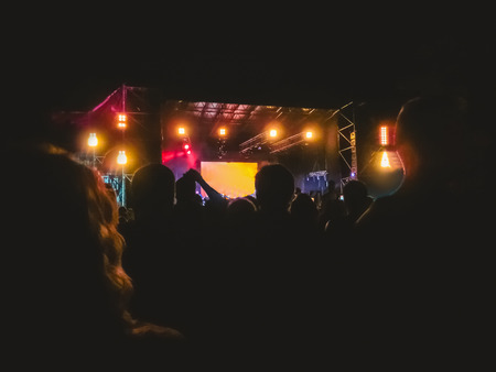 The party, concert concept. Crowd raising their hands and enjoying great rock festival. blur bokeh for background.の写真素材