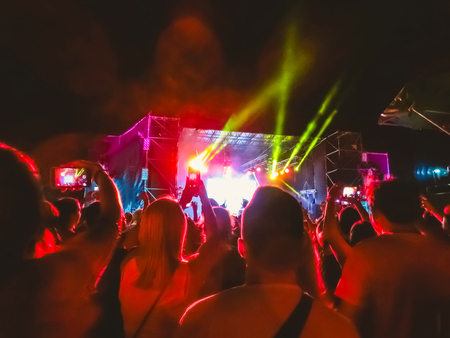 The party, concert concept. Crowd raising their hands and enjoying great rock festival. blur bokeh for background.の写真素材