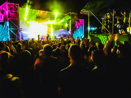The party, concert concept. Crowd raising their hands and enjoying great rock festival. blur bokeh for background.の写真素材