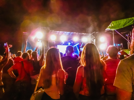 The party, concert concept. Crowd raising their hands and enjoying great rock festival. blur bokeh for background.の写真素材