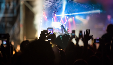 The party, concert concept. Crowd raising their hands and enjoying great rock festival. blur bokeh...