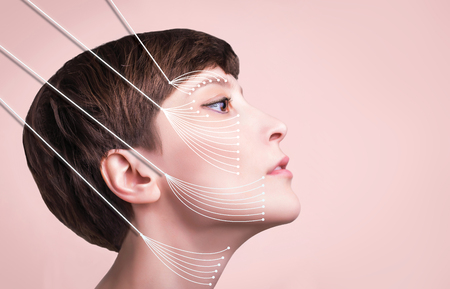 Young female with clean fresh skin. Beautiful woman. Female face and neck. Portrait of young caucasian woman at studio isolated on pastel. Short haircut, long neck, perfect skin. Lifting by gold thread conceptの写真素材