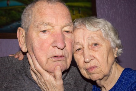 Portrait of a sad sick elder couple at home. The senior people and depression concept