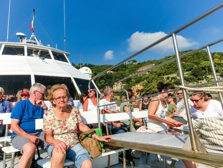 Portofino, Italy - September 13, 2019: People at boat tour at beautiful bay with colorful houses in...