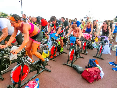 Rapallo, Italy - September 15, 2019: People performing a spinning session outdoors in an urban park of Liguria. Athlets training an their special bikers to keep healthyのeditorial素材