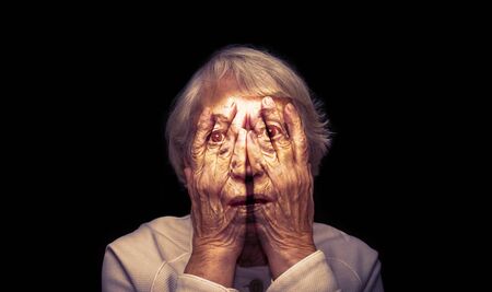 Old Aging Woman Scared of her Wrinkled Faceの写真素材