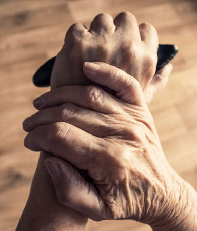 Lonely old woman leaning on walking stick and thinking about life, retirement concept