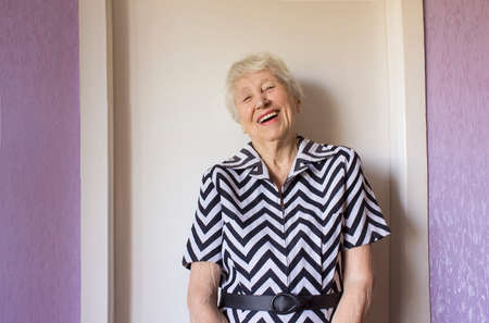 An happy old elderly senior woman laughing to camera.