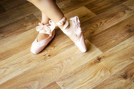 Young little ballerina in pointe shoes at home. Dreams and ballet dance concept