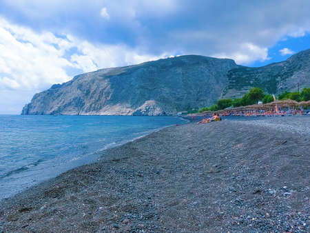 Santorini, Greece - June 10, 2015: The people resting at black sand Perissa Beach, Santorini, Greece on June 10, 2015のeditorial素材