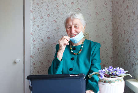 COVID-19 Stay connected. Happy senior woman at home video calling family on laptop or online...