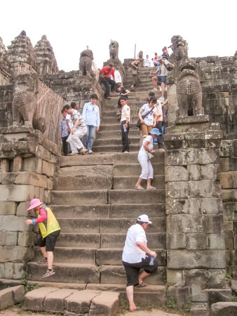 Siem Reap, Cambodia - February 16, 2011: The people descending the steps of old temple, Angkor, Cambodiaのeditorial素材