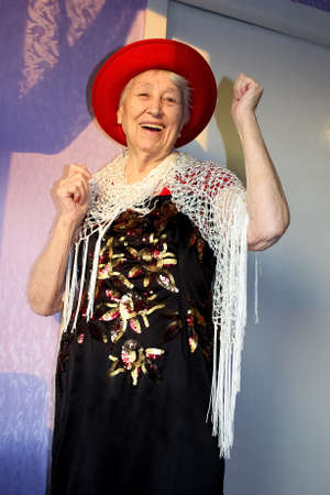Happy smiling funny senior woman wearing beads dancing at home