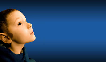 Portrait of astonished child on blue background. Concept of little spectator