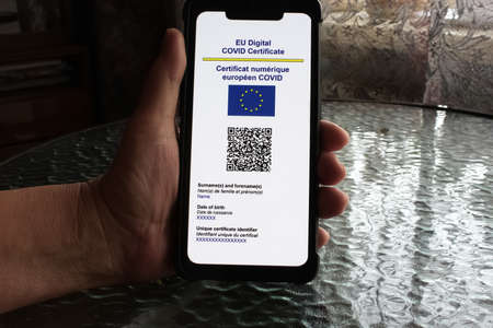 close up of view hands women holding smartphone display on app mobile vaccinated COVID-19 or coronavirus certificate, immunity vaccine passport, new normal travel of tourist concept.のeditorial素材