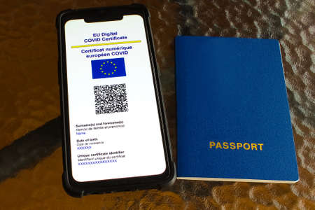 close up of view hands women holding smartphone display on app mobile vaccinated COVID-19 or coronavirus certificate, immunity vaccine passport, new normal travel of tourist concept.のeditorial素材