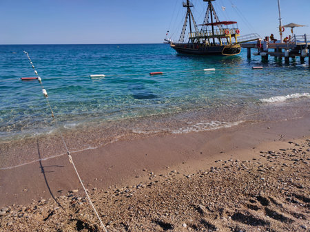 Tekirova, Antalya, Turkey - May 11, 2021: Bay in mediterranean sea with old yacht and fun sun in Turkey.のeditorial素材