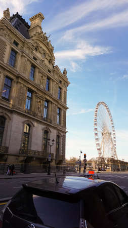 Paris, France - January 01, 2022: People going near Ferris wheel Roue de Paris on the Place de la Concorde from Tuileries Garden in Paris, Franceのeditorial素材