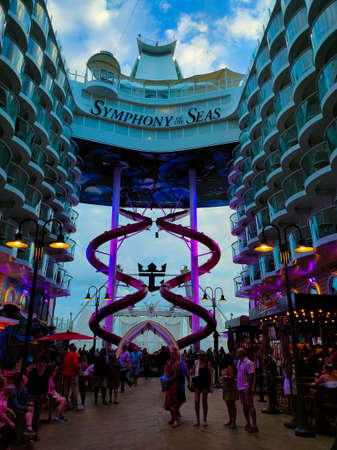 Miami, USA - April 29, 2022: The passengers going at Promenade at cruise liner Symphony of the Seas...