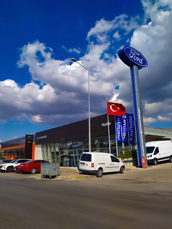 Izmir, Turkey - September 22, 2022: Ford logos on the dealership of the area, against blue sky. It is the symbol of the american vehicle manufacturer.のeditorial素材