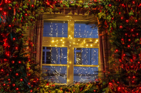 Christmas tree and fireplace seen through a wooden cabin window indoorの写真素材